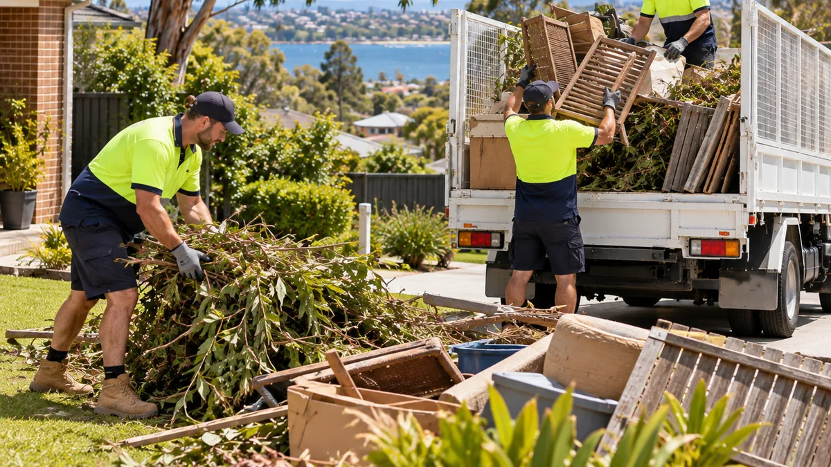 Crew collecting tree cuttings and green waste on a large block on the edge of Geelong, with the bay and hills behind